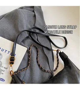 Detail of black pebbled leather tote with gold hardware and dual chain strap options