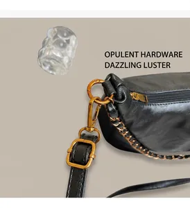 Detail of vintage gold ring hardware and chain strap on black leather tote bag