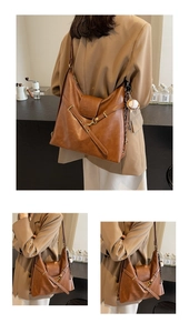 Détail du sac cabas en cuir mat marron avec rabat et pendentif de baseball rétro
