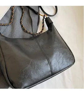Close-up of vintage black hobo bag with soft pleated leather and chain shoulder strap