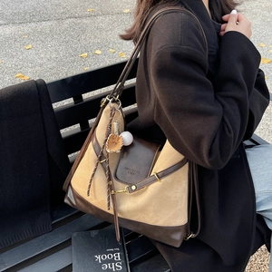 Sac fourre-tout vintage en daim kaki et cuir marron avec charme créatif sur un banc de parc