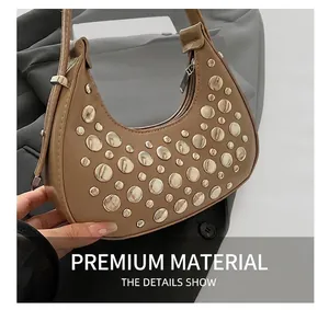 Detail of khaki crescent bucket bag with silver metal rivets and smooth zipper closure