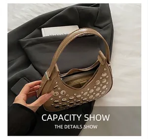 Interior view showing large capacity and zipper pocket of brown studded crescent bag