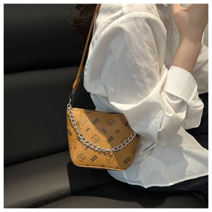 Détail d'un sac carré en cuir marron avec imprimé ours et chaîne argentée