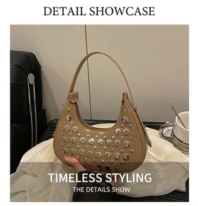 Detailed macro view of khaki hobo bag featuring dense silver rivets and matte leather texture
