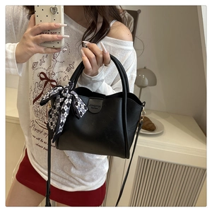 Detail of a black leather bucket bag with checkered scarf and JINGPIN fashion logo
