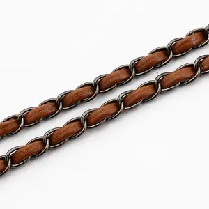 Close-up of brown leather and dark metal chain braided shoulder strap detail