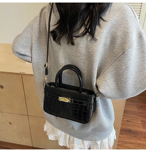 Crossbody view of black crocodile pattern mini square bag with golden turn-lock