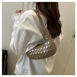 Detail of khaki crescent bag featuring silver studs and adjustable shoulder strap