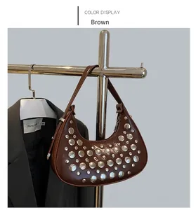 Detailed view of coffee-colored moon bag featuring polished silver stud rivets and a zipper