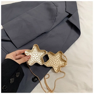Détail intérieur du sac à main en métal doré en forme d'étoile avec strass et chaîne