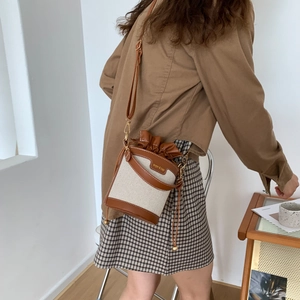 Sac seau rétro en toile avec garniture en cuir brun porté en bandoulière de côté