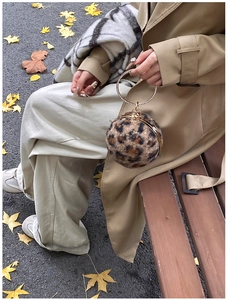 Macro detail of plush leopard print sphere bag with rhinestone-encrusted metal handle