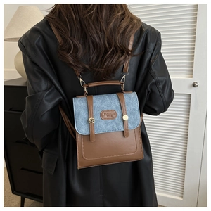 Detailansicht der braunen Leder- und blauen Denim-Mini-Rucksacktasche mit Goldschnallen