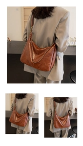Detail view of large brown faux leather shoulder bag with decorative bronze chain strap