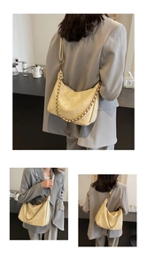 Detail showing the crescent leather shoulder bag with gold chain and matte texture