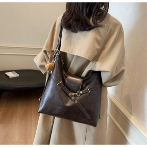 Détail du grand cabas en cuir marron avec boucle dorée et pendentif ours mignon