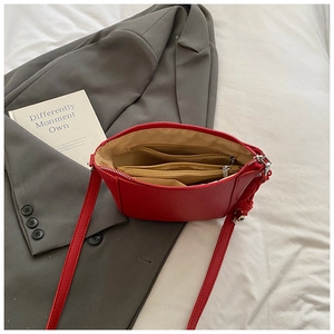 Detailed interior of red pebbled leather bucket bag showing multi-compartment lining