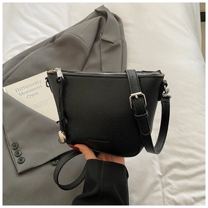 Close-up of black lychee grain texture and adjustable silver buckle on bucket bag