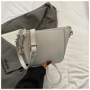 Close-up of silver lychee texture leather bucket bag with metal zipper and strap detail