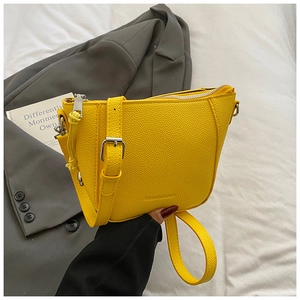 Detail of yellow lychee grain leather bucket bag with silver zipper and embossed logo