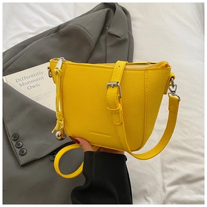 Detail of yellow lychee grain bucket bag featuring silver zipper and adjustable strap