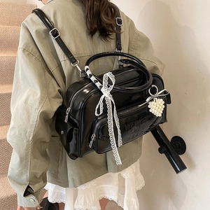 Zaino chic in pelle verniciata nera con fiocco in pizzo e pendente a cuore per donna