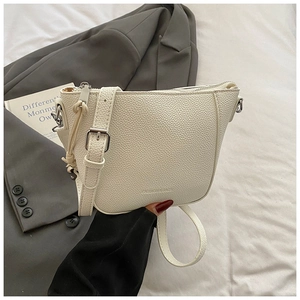 Close-up of white lychee pattern crossbody bag with silver hardware and fashion text