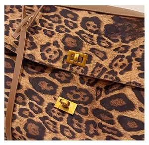 Detail of leopard print tote bag featuring dual golden metal locks and soft velvet texture