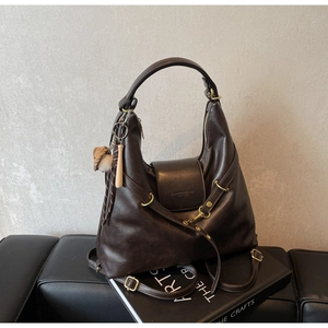 Détail du sac cabas marron foncé avec anneaux métalliques et pendentif de baseball