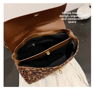 Macro shot of leopard print tote bag interior with multiple compartments and gold twist lock