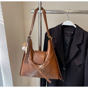 Détail d'un sac cabas marron vintage avec boucle décorative et pendentif de sac