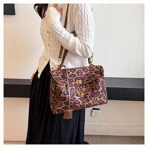 Detailed close-up of leopard print crossbody bag with metallic clasp and leather strap