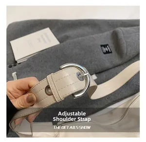 Detail of beige adjustable leather shoulder strap with silver buckle and fine stitching