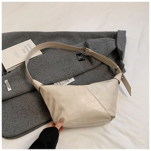 Detail of cream pleated leather dumpling bag featuring diagonal stitching and silver buckle