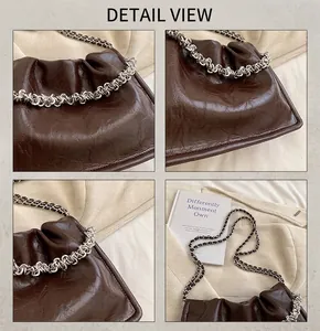 Detail view of dark brown oil-wax leather texture with silver chain on pleated bag