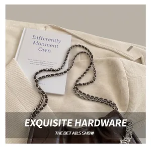 Detail of dark brown crinkled leather handbag with silver woven metal chain strap