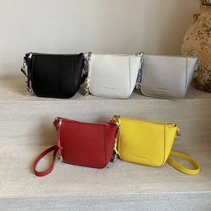 Chic textured crossbody bucket bags in multiple colors with knot and bell charm details