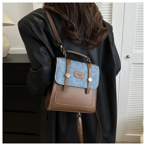 Details eines Vintage-Mini-Rucksacks aus braunem Kunstleder und blauem Denim