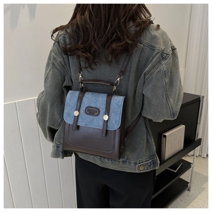 Nahaufnahme eines Vintage-Rucksacks aus Denim und braunem Leder mit Metallschnalle