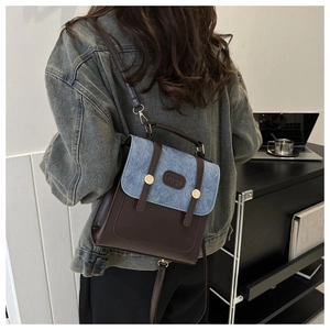 Nahaufnahme eines Retro-Rucksacks aus Denim und Leder mit Schnallen und Metallknöpfen