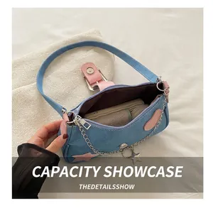 Dettaglio interno della borsa in denim con finiture rosa e toppe a forma di cuore