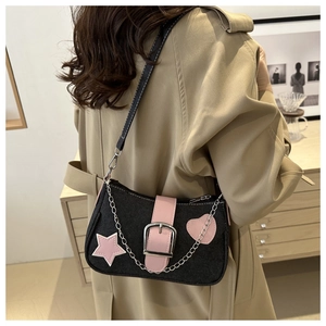 Dettaglio della borsa a spalla in denim nero con toppe a stella rosa e catena d'argento