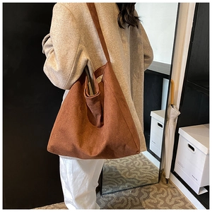 Detail view of large brown suede tote bag with a soft texture and minimalist urban design
