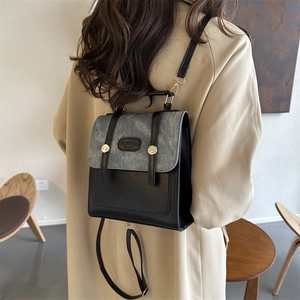 Minimalistischer Rucksack aus schwarzem Leder und grauem Stoff mit goldener Schnalle