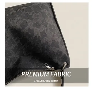 Gros plan du tissu jacquard floral 3D et du zip en métal argenté sur un sac fourre-tout
