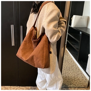 Detailed view of the large dark brown suede tote bag worn over the shoulder for commute