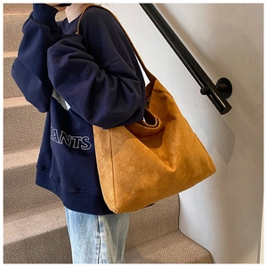 Close-up of mustard yellow suede tote bag showing large capacity and matte leather texture