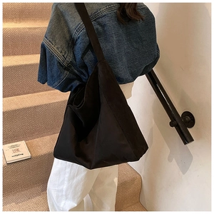 Detail view of a large black Hobo tote bag with mixed materials and wide shoulder strap