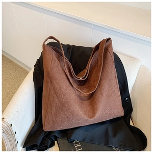 Macro shot of dark brown suede tote bag texture on an armchair for autumn style